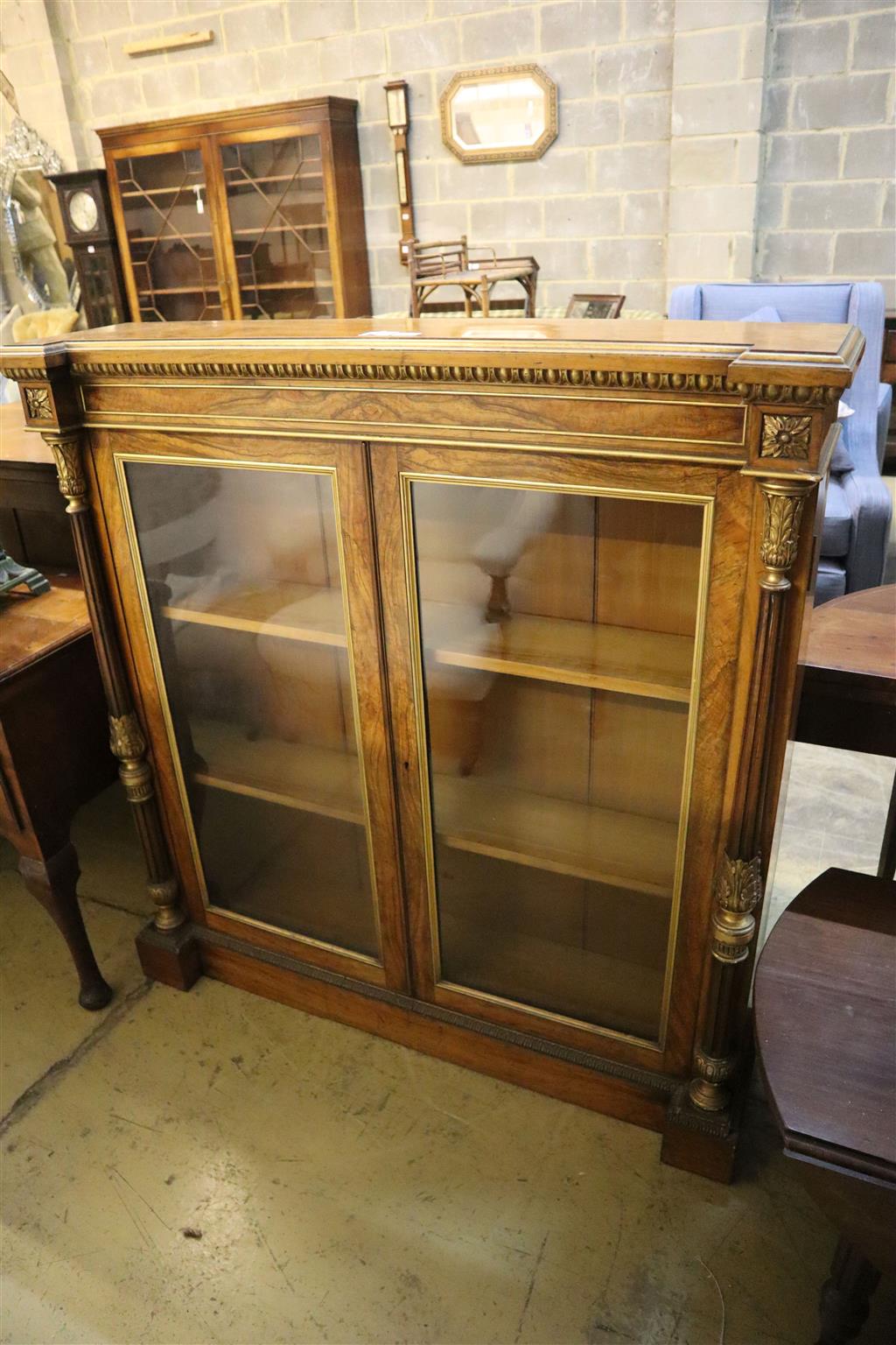 A Victorian parcel gilt walnut inverse breakfront bookcase, width 112cm, depth 27cm, height 118cm